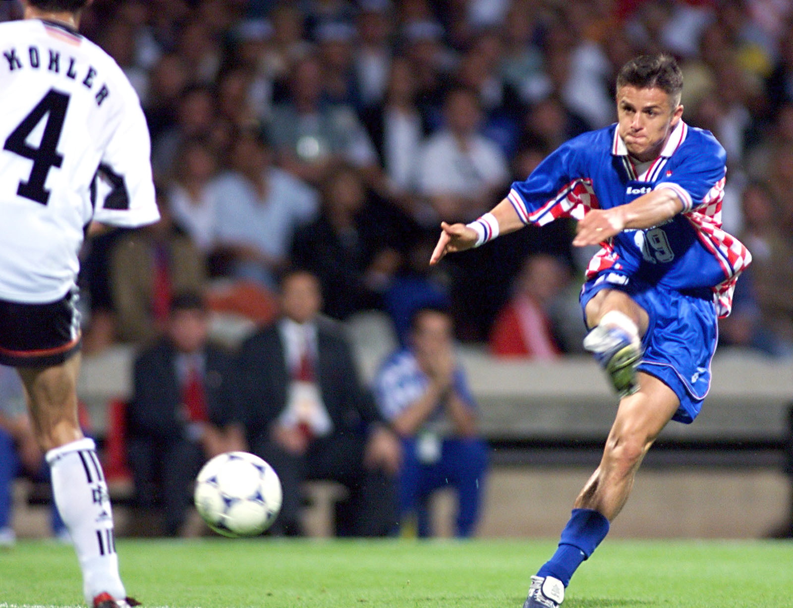 Croatian forward Goran Vlaovic kicks the ball past German defender Juergen Kohler (L) and goalkeeper Andreas Koepke (not in the picture) to score the 0-3 victory over German during the 1998 Soccer World Cup quarter-final match between Germany and Croatia 04 July at Gerland stadium in Lyon, central France. Croatia will play host France in the World Cup semi-finals in Saint-Denis 08 July. (ELECTRONIC IMAGE)   AFP PHOTO (Photo by GERARD CERLES / AFP)