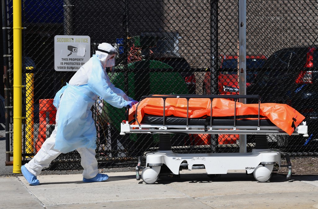 (FILES) In this file photo taken on April 02, 2020 Medical staff move bodies from the Wyckoff Heights Medical Center to a refrigerated truck on April 2, 2020 in Brooklyn, New York. - New York state's death toll rose to 3,565 on April 4, 2020, Governor Andrew Cuomo said, up from 2,935 the previous day, in the largest 24-hour jump recorded there. The state has now recorded 113,704 positive cases -- 63,306 in New York City -- just 6,000 short of hard-hit Italy's total. (Photo by Angela Weiss / AFP)