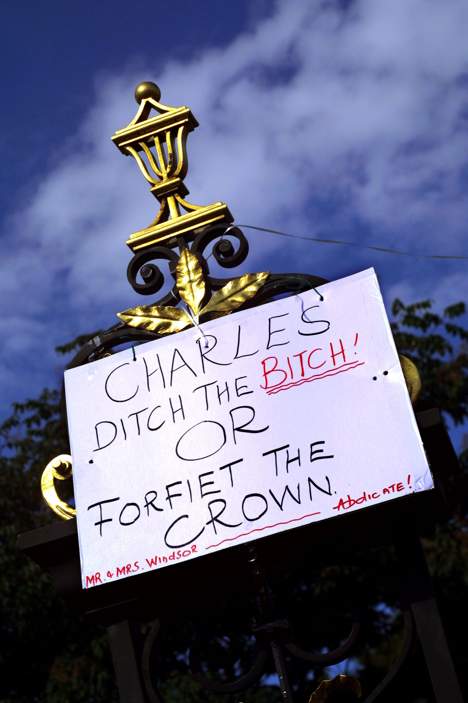 393903 07: A sign calling for Prince Charles to end his relationship with Camilla Parker-Bowles hangs at the gates of Kensington Palace on the 4th anniversary of the death of Diana, Princess of Wales, August 31, 2001 in London, United Kingdom. (Photo by Sion Touhig/Getty Images)