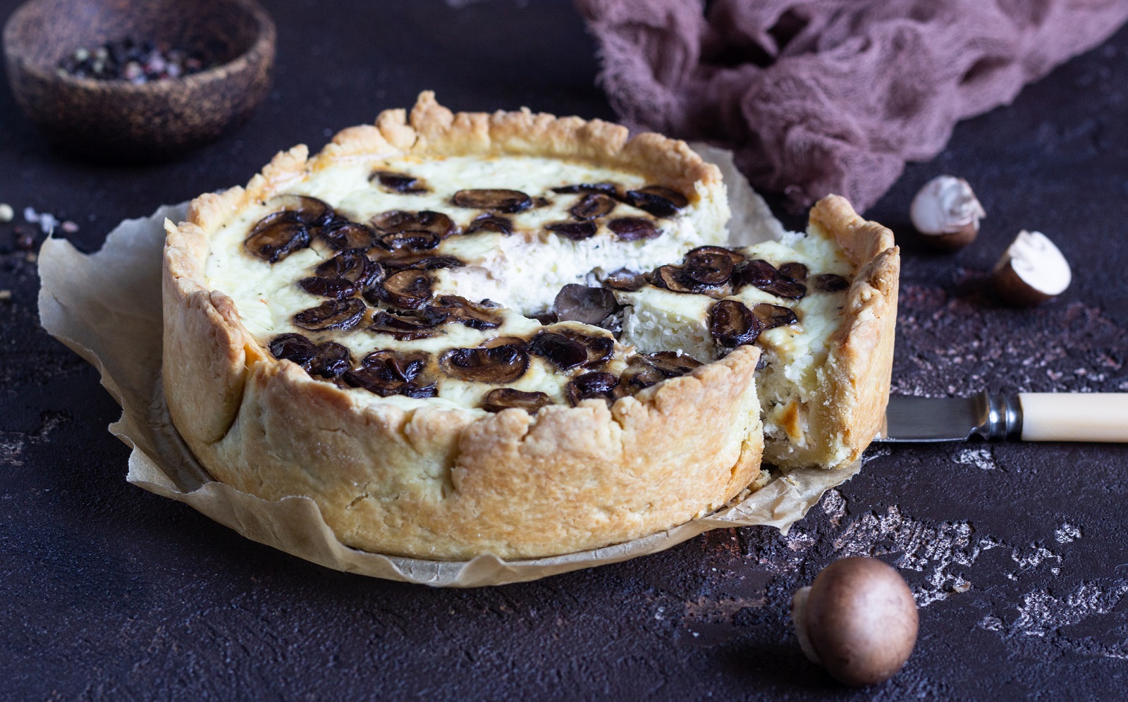 Quiche with champignons and cheese on dark brown concrete background. Savory tart with mushrooms. Copy space.