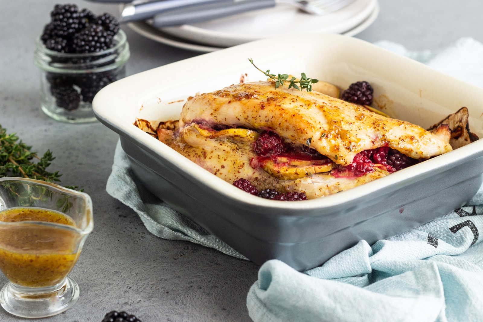 Baked turkey or chicken breast stuffed with apples and blackberries. Light grey background.