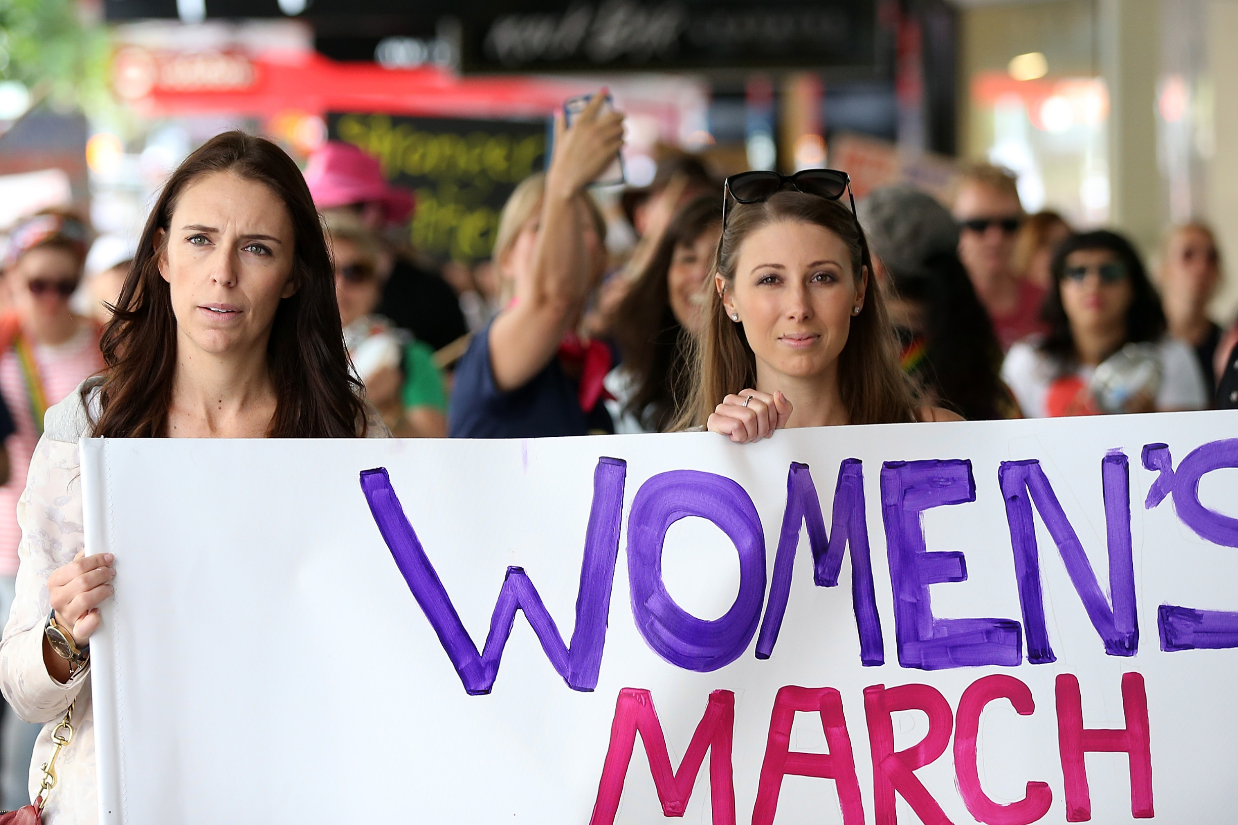 AUCKLAND, NEW ZEALAND - JANUARY 21:  Labour MP Jacinda Ardern (L) and musician, writer, activist Lizzie Marvelly (C) join thousands of people marching up Queen Street on January 21, 2017 in Auckland, New Zealand. The marches in New Zealand were organised to show solidarity with those marching on Washington DC and around the world in defense of women's rights and human rights.  (Photo by Fiona Goodall/Getty Images)