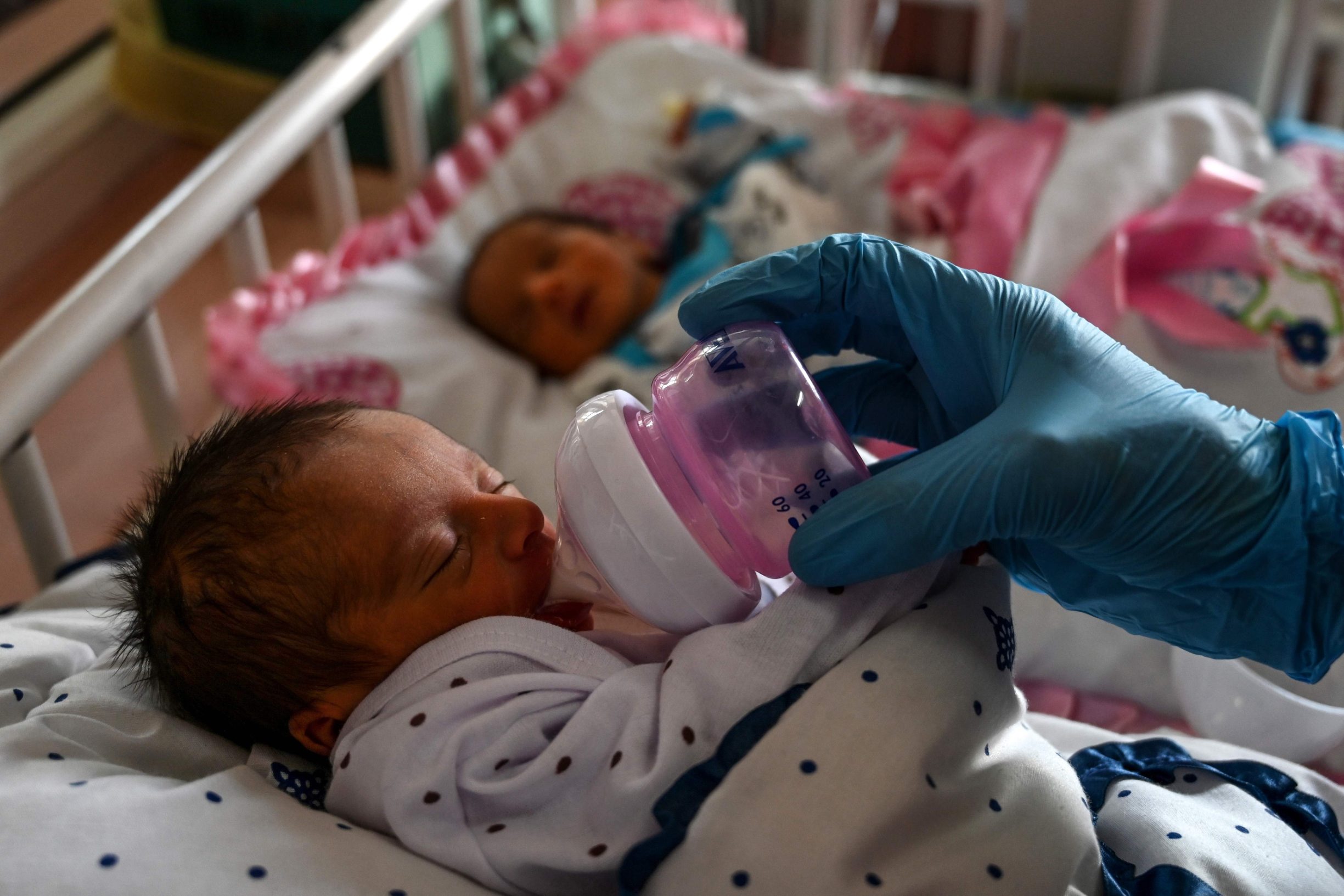 A nurse feeds a newborn baby rescued and brought to Ataturk Children hospital, after the mother was killed during a gunmen attack on a maternity hospital, in Kabul on May 15, 2020. - Gunmen who stormed a hospital in the Afghan capital this week had come to 