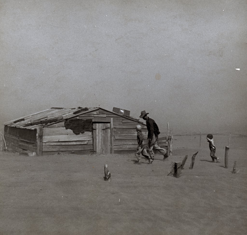 Photograph of a farmer and son walking in the face of a dust storm in Cimarron County, Oklahoma. Photograph taken by Arthur Rothstein (1915-1985).