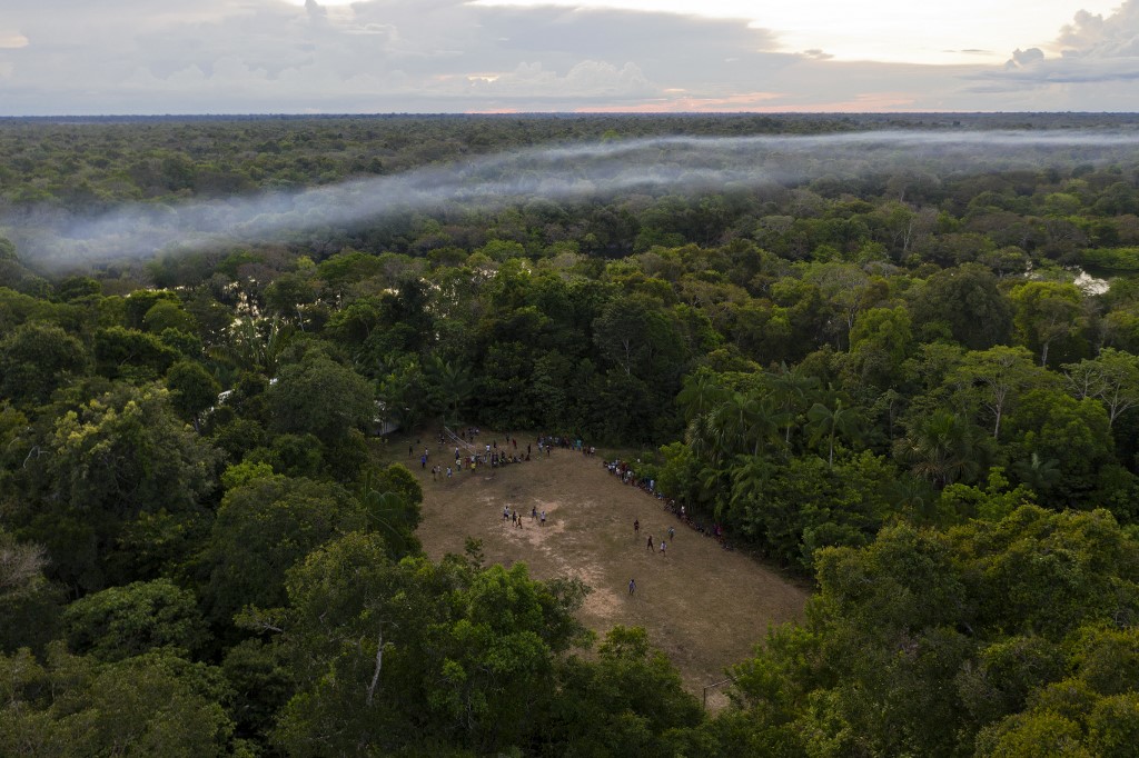 Aerial view of a football game taking place in a forest clearing in the Bauana community, municipality of Carauari, in the heart of the Brazilian Amazon Forest, on March 15, 2020. - Many young people in the heart of the Amazon rainforest choose their community over the city. (Photo by Florence GOISNARD / AFP)