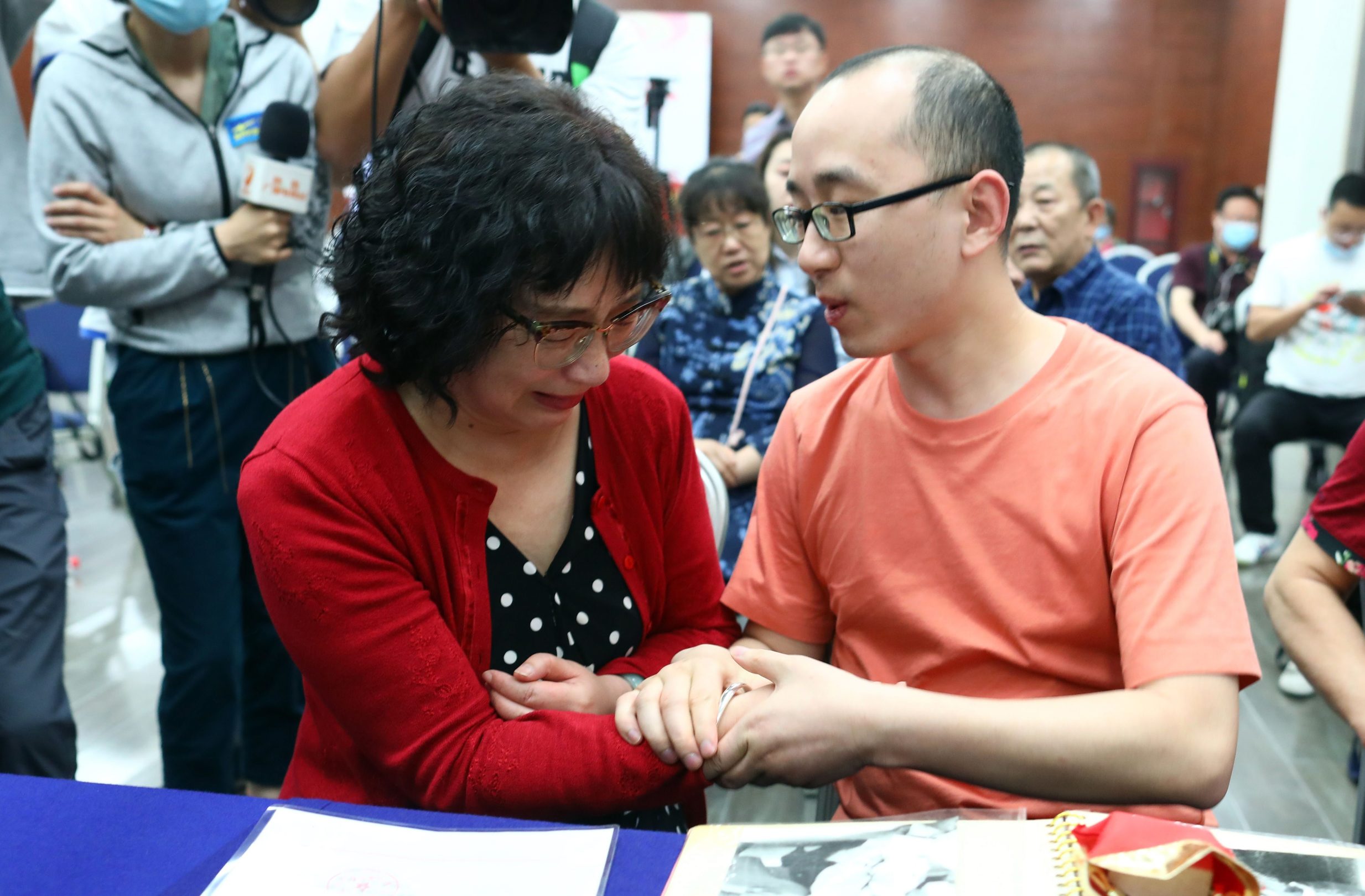 This photo taken on May 18, 2020 shows Mao Yin (R) with his mother Li Jingzhi after they were reunited in Xian, in China's northern Shaanxi province. - A Chinese man who was kidnapped as a toddler 32 years ago has been reunited with his biological parents, after police used facial recognition technology to track him down. (Photo by STR / AFP) / China OUT
