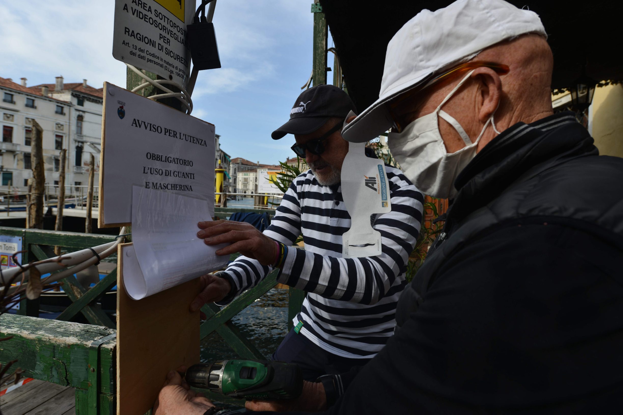 Gondoliers wearing a face mask resume service at the San Toma embankment on a Venice canal on May 18, 2020 during the country's lockdown aimed at curbing the spread of the COVID-19 infection, caused by the novel coronavirus. - Restaurants and churches reopen in Italy on May 18, 2020 as part of a fresh wave of lockdown easing in Europe and the country's latest step in a cautious, gradual return to normality, allowing businesses and churches to reopen after a two-month lockdown. (Photo by ANDREA PATTARO / AFP)