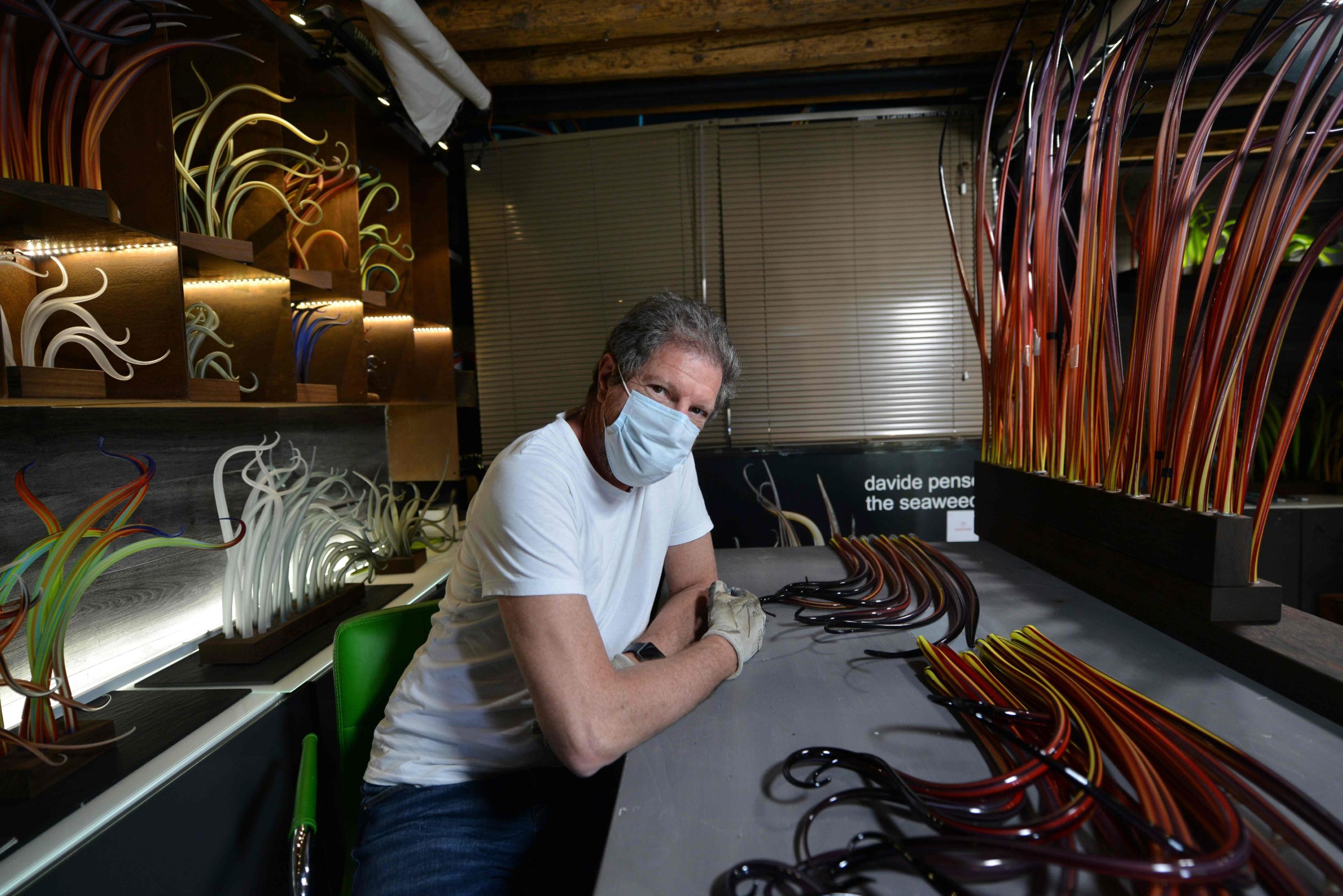 Italian glass artist Davide Penso poses in his studio on May 18, 2020 in Murano during the country's lockdown aimed at curbing the spread of the COVID-19 infection, caused by the novel coronavirus. - Restaurants and churches reopen in Italy on May 18, 2020 as part of a fresh wave of lockdown easing in Europe and the country's latest step in a cautious, gradual return to normality, allowing businesses and churches to reopen after a two-month lockdown. (Photo by ANDREA PATTARO / AFP)