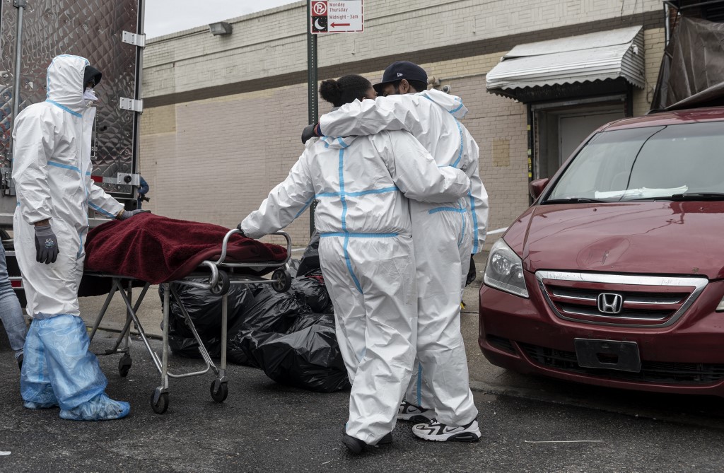 People in Hazmat suits transport a deceased body on a stretcher outside a funeral home in Brooklyn on April 30, 2020 in New York City. - Dozens of bodies have been discovered in unrefrigerated overflow trucks outside the Andrew T. Cleckley Funeral Home, following a complaint of a foul odor. (Photo by Johannes EISELE / AFP)