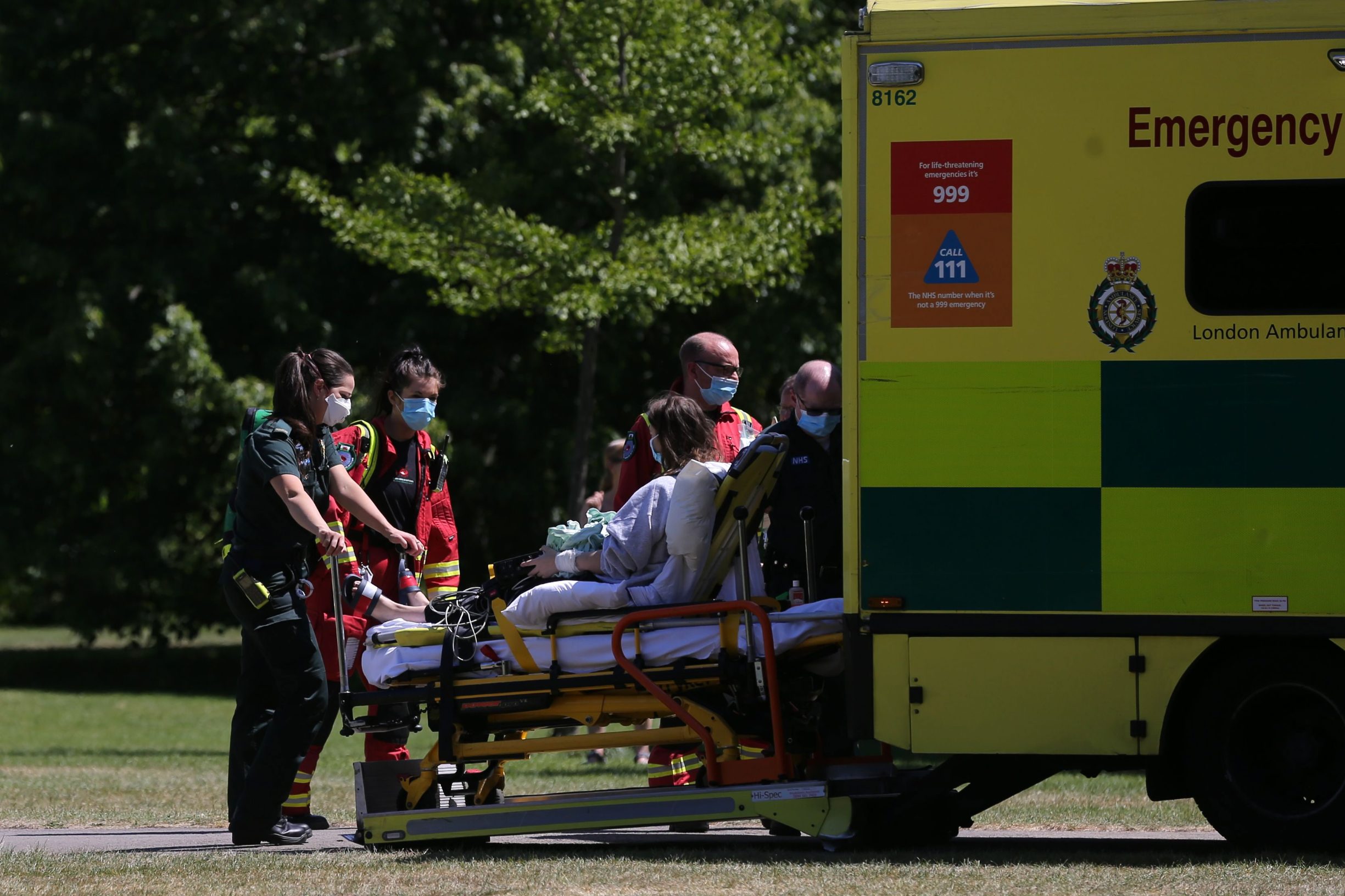 Members of the emergency services wearing PPE (personal protective equipment) transfer a patient into an ambulance in Regent's Park in London on May 20, 2020, as temperatures in the capital are expected to reach 28C (82.4F). - Britain's official coronavirus death toll is at least 41,000 with almost 10,000 dead in care homes in England and Wales alone, according to a statistical update released on Tuesday. Some 41,020 deaths where COVID-19 was mentioned on the death certificate were registered across the UK by May 8, according to the Office for National Statistics (ONS). (Photo by ISABEL INFANTES / AFP)