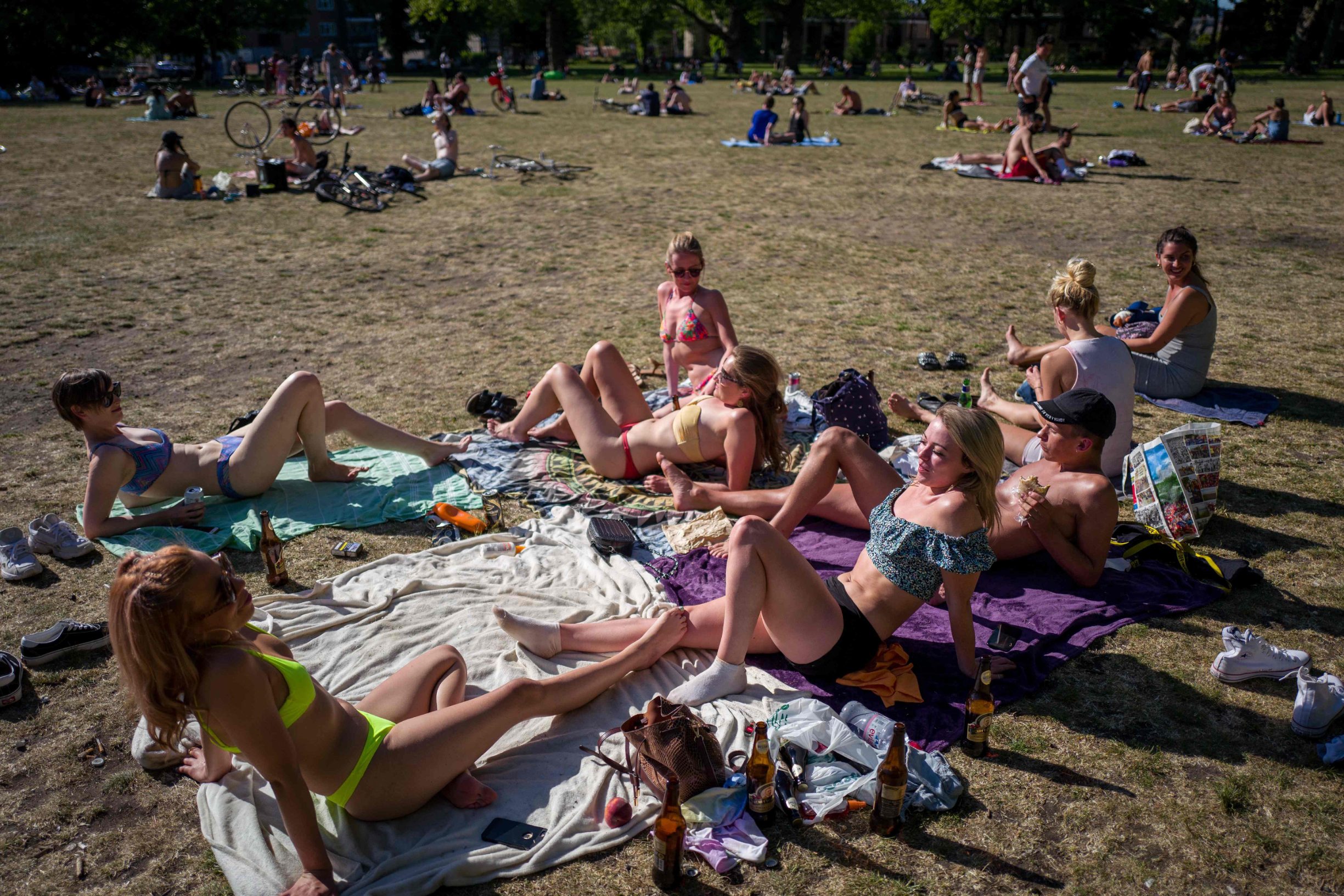People enjoy the sunshine in London Fields, north east London on May 20, 2020, as temperatures in the capital are expected to reach 28C (82.4F). - British Prime Minister Boris Johnson said Wednesday the country will have 25,000 virus tracing staff recruited by June so the country can 