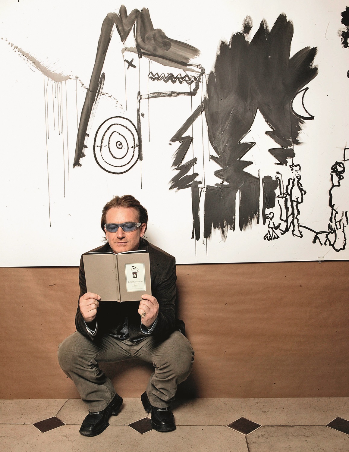 DUBLIN, IRELAND - OCTOBER 3: Singer Bono stands in front of an illustration at the book launch for 