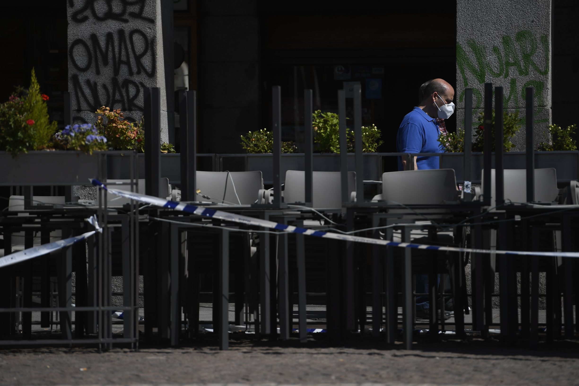 A man prepares a terrace bar at the Plaza Mayor in Madrid on May 25, 2020 as coronavirus lockdown measures will finally be eased for people in Madrid and Barcelona. - The Madrid and Barcelona regions, the most populated in the country, and a large part of Castile-Leon in the northwest are moving into the first phase of Spain's four-phase deconfinement programme, following what has been one of the strictest lockdowns in the world. (Photo by PIERRE-PHILIPPE MARCOU / AFP)