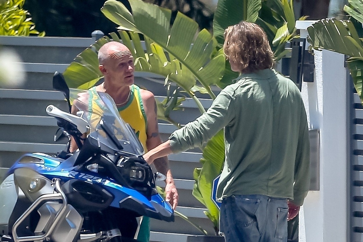 Malibu, CA  - *EXCLUSIVE*  - *Web Must Call For Pricing*  Rocker Flea gets animated with friend Brad Pitt in Malibu as he shows him his BMW  R1250 motorcycle. The actor stepped out sporting longer hair that was reminiscent of his glorious tresses in 