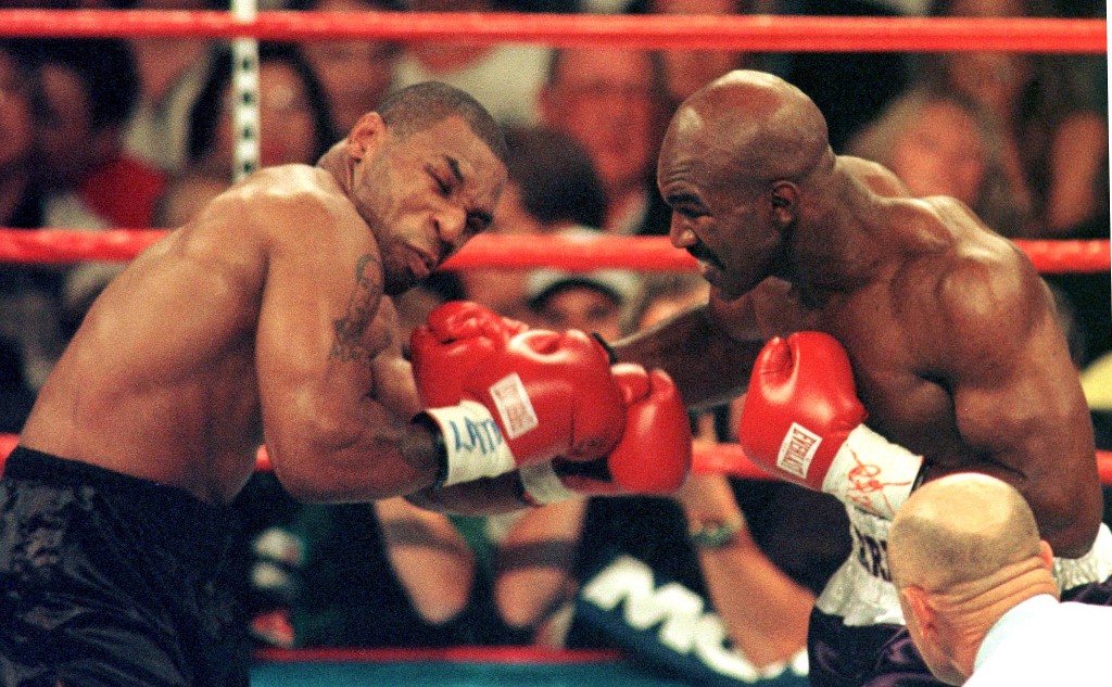 World Boxing Association heavyweight champion Evander Holyfield (R) lands a right on challenger Mike Tyson during the first round of their fight in the MGM Grand Garden Arena 28 June. Holyfield won by disqualification after Tyson bit Holyfield's ears. AFP PHOTO/JOHN GURZINSKY (Photo by JOHN GURZINSKI / AFP)