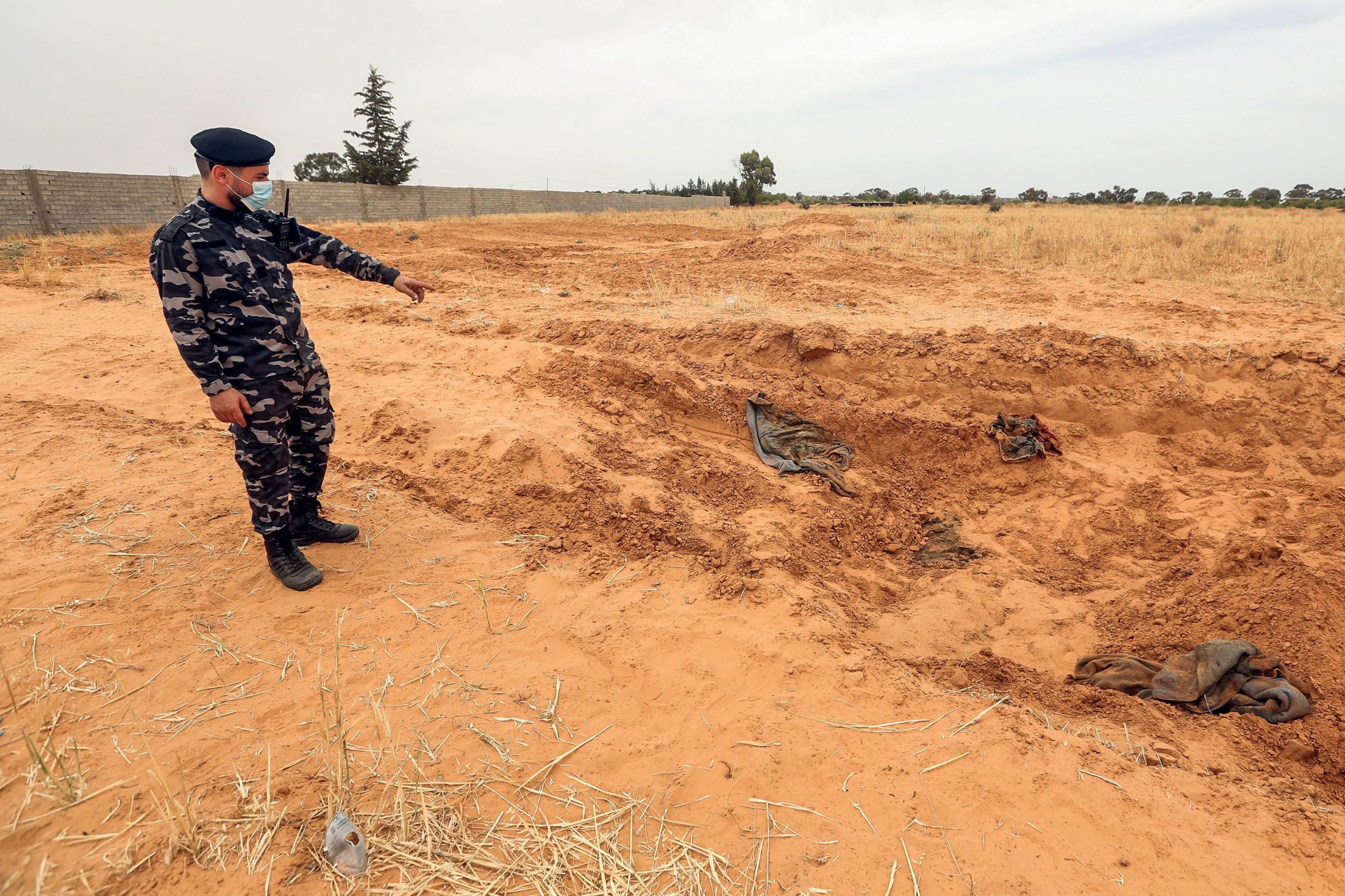 A member of security forces affiliated with the Libyan Government of National Accord (GNA)'s Interior Ministry stands at the reported site of a mass grave in the town of Tarhuna, about 65 kilometres southeast of the capital Tripoli on June 11, 2020. - The United Nations mission to Libya on June 11 voiced 