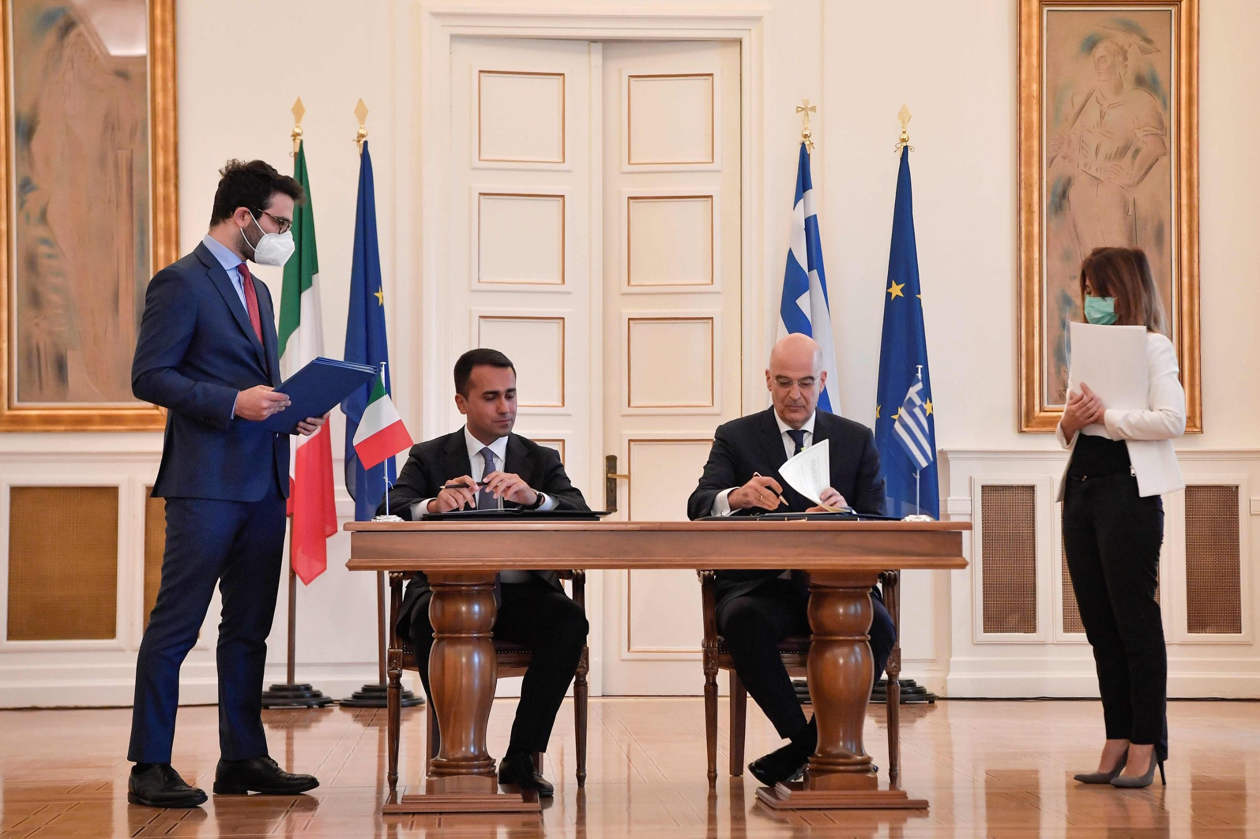 Italian foreign minister Luigi Di Maio and his Greek counterpart Nikos Dendias (R) sign a maritime zone agreement at the foreign ministry in Athens on June 9, 2020. (Photo by Louisa GOULIAMAKI / AFP)
