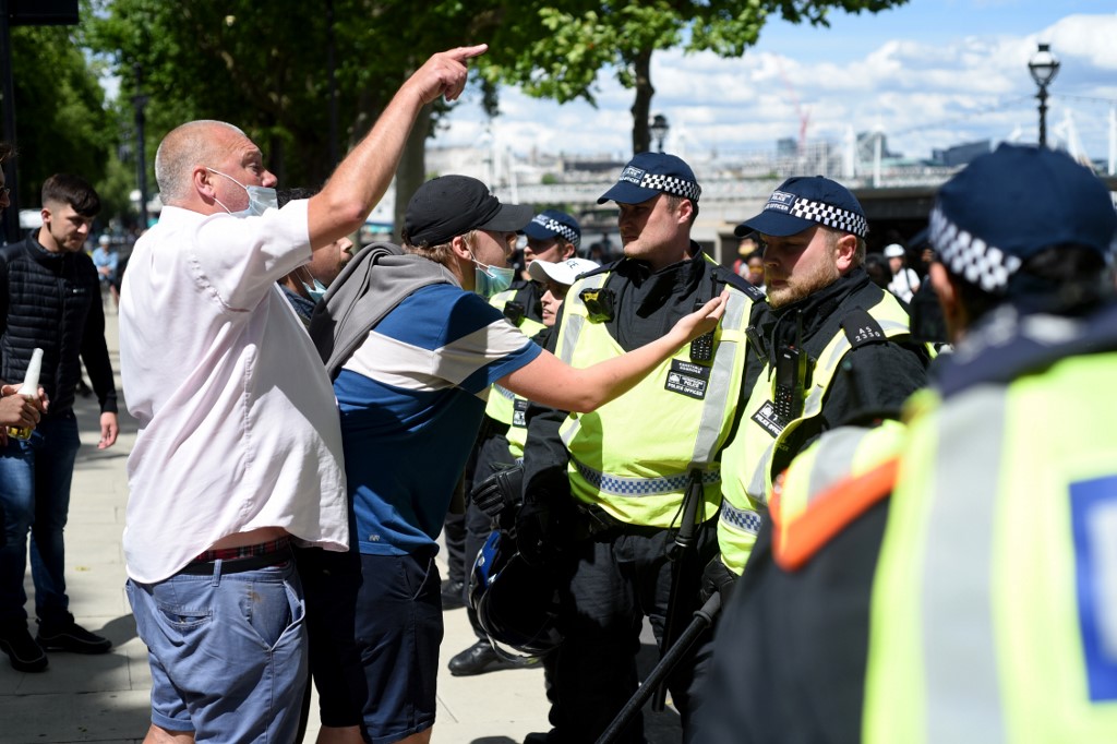 LONDON, UNITED KINGDOM - JUNE 13: An activist argues with a police officer on Parliament Street on June 13, 2020 in London, United Kingdom. Following a social media post by the far-right activist known as Tommy Robinson, members of far-right linked groups have gathered around statues in London. Several statues in the UK have been targeted by Black Lives Matter protesters for their links to racism and the slave trade. Kate Green / Anadolu Agency