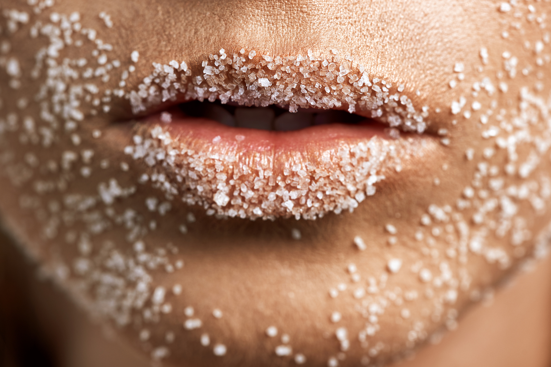 macro shot of unrecognizable woman skin and lips with sugar on it, beauty treatment concept.