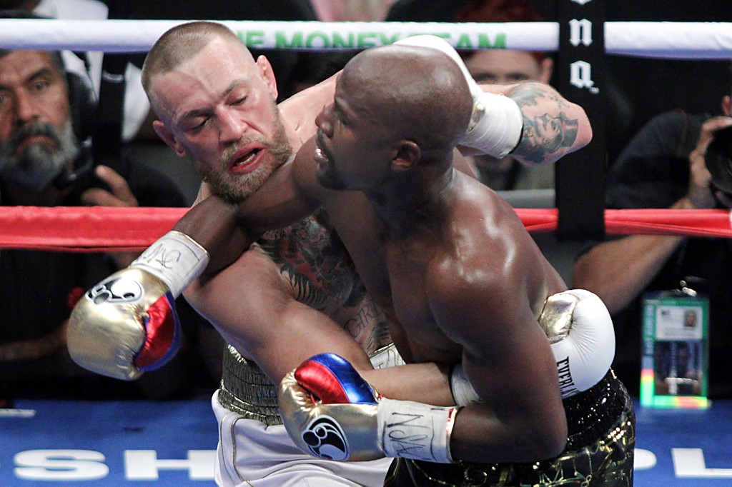 Mixed martial arts star Conor McGregor (L) competes with boxer Floyd Mayweather Jr. during their fight at the T-Mobile Arena in Las Vegas, Nevada on August 26, 2017. - Floyd Mayweather outclassed Conor McGregor with a 10th-round stoppage on August 26 to win their money-spinning superfight and clinch his 50th straight victory. (Photo by John Gurzinski / AFP)