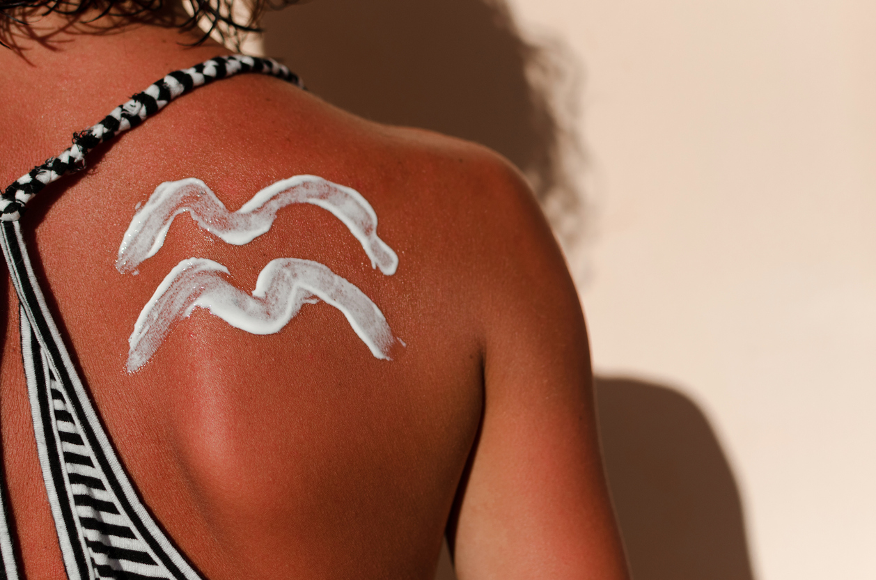 Sunburn woman skin with drawing waves of cream for UV protection.
