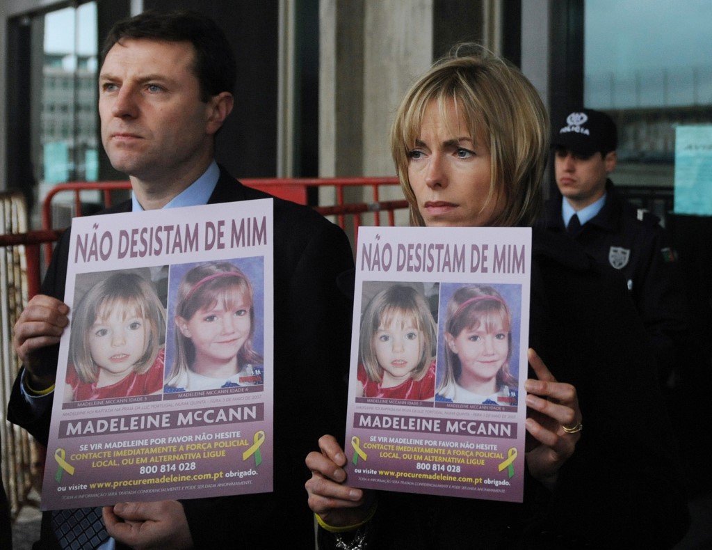 Gerry (L) and Kate McCann pose with boards portraiting their missing daughter Madeleine reading 