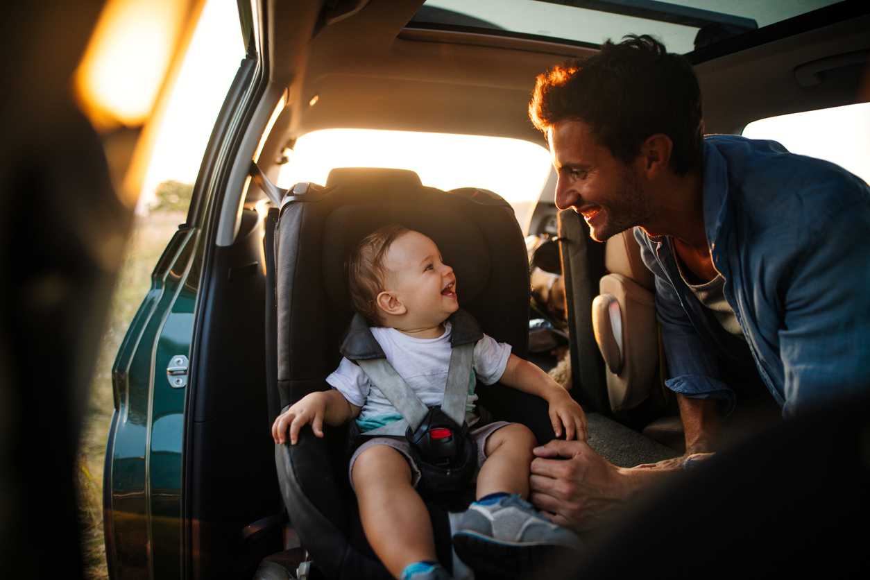 Photo of young father spending time with his son by taking him on a road trip in nature