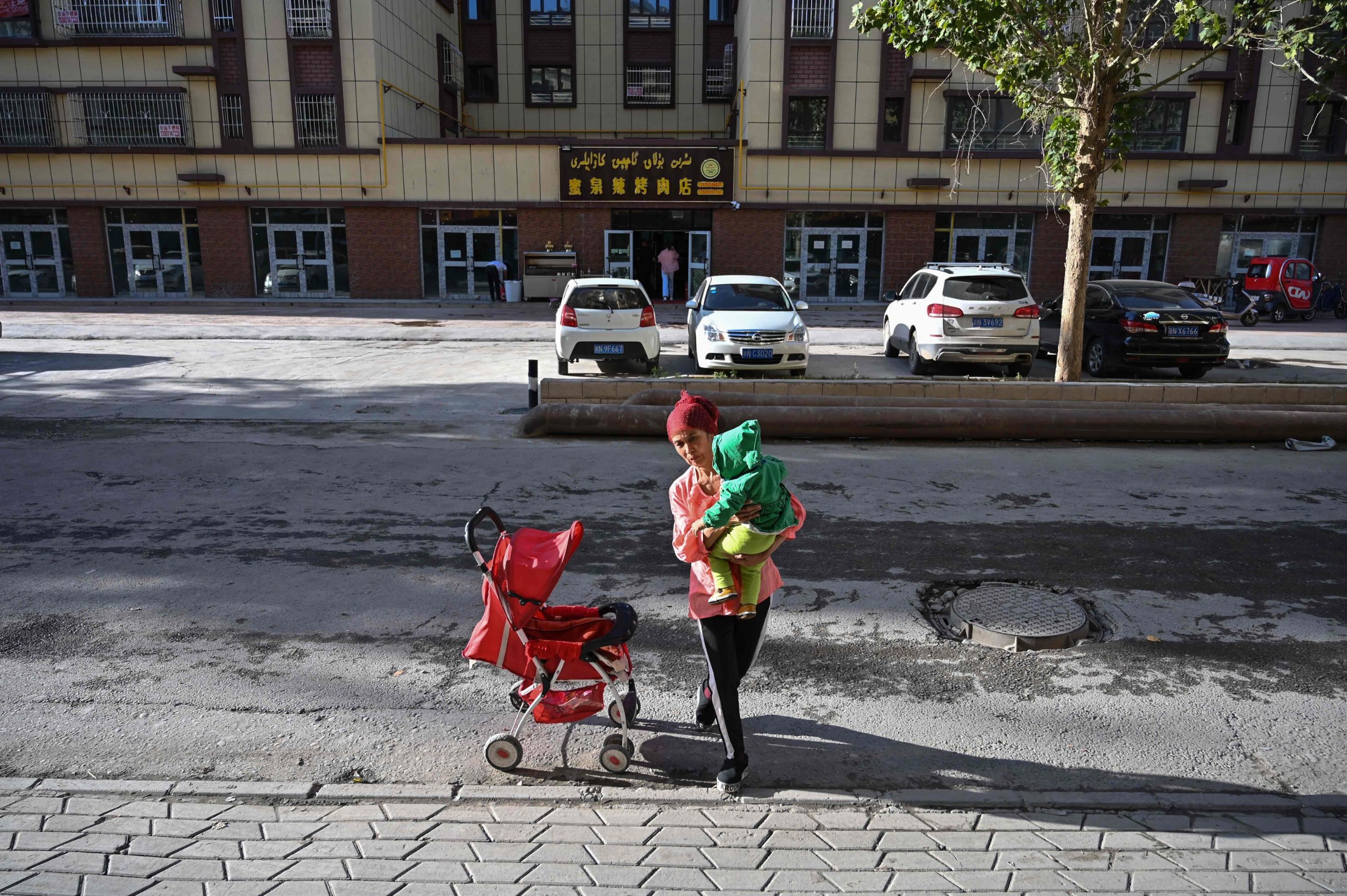 (FILES) This file photo taken on September 11, 2019 shows a woman walking in an ethnic Uighur neighbourhood in Aksu in China's northwest Xinjiang region. - Chinese authorities are carrying out forced sterilisations of women in an apparent campaign to curb the growth of ethnic minority populations in the western Xinjiang region, according to research published on June 29, 2020. (Photo by HECTOR RETAMAL / AFP)