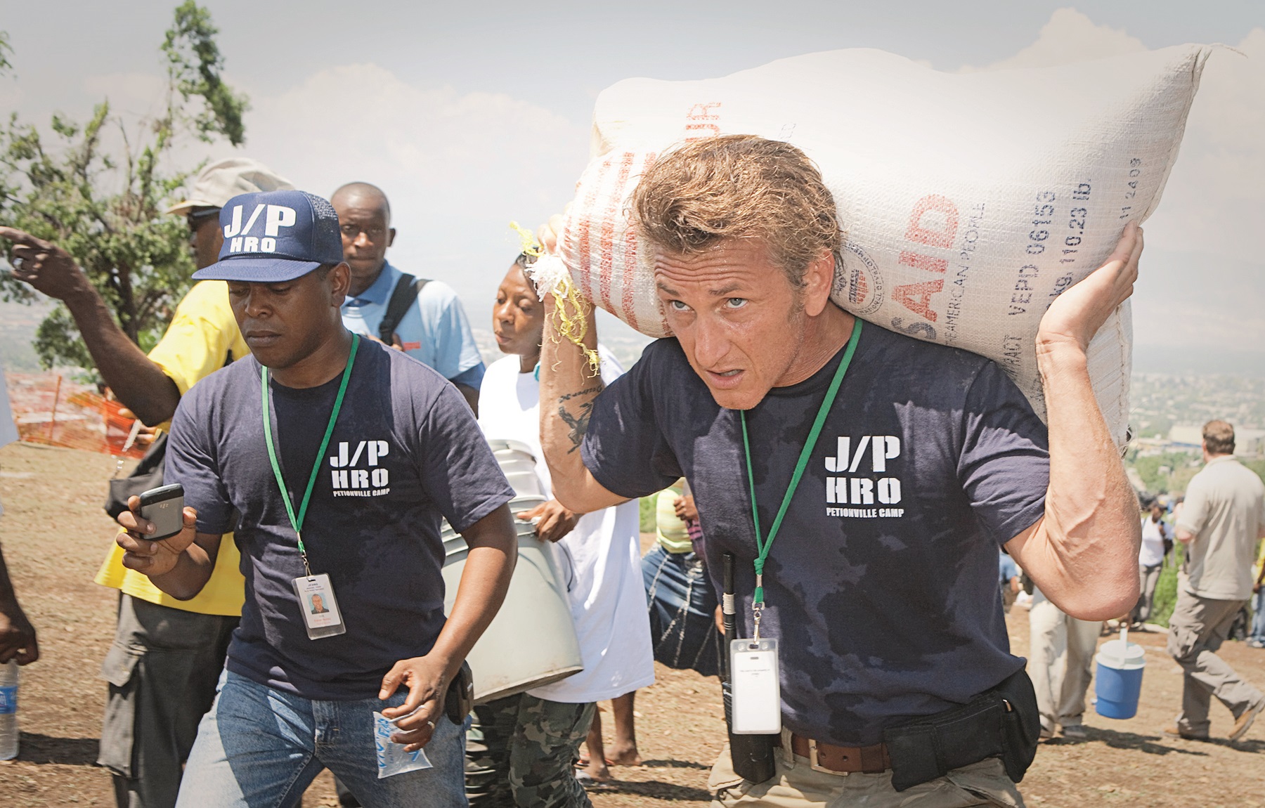 PETIONVILLE, HAITI - APRIL 10:  Actor Sean Penn carries belongings of a shelter camp resident as they are prepared to be relocated to a new camp April 10, 2010 in Petionville, Haiti. Residents of the Petionville Club camp are being relocated to a new camp at Corail Cesselesse due to risks of flooding and landslides at the current location.  (Photo by Lee Celano/Getty Images)