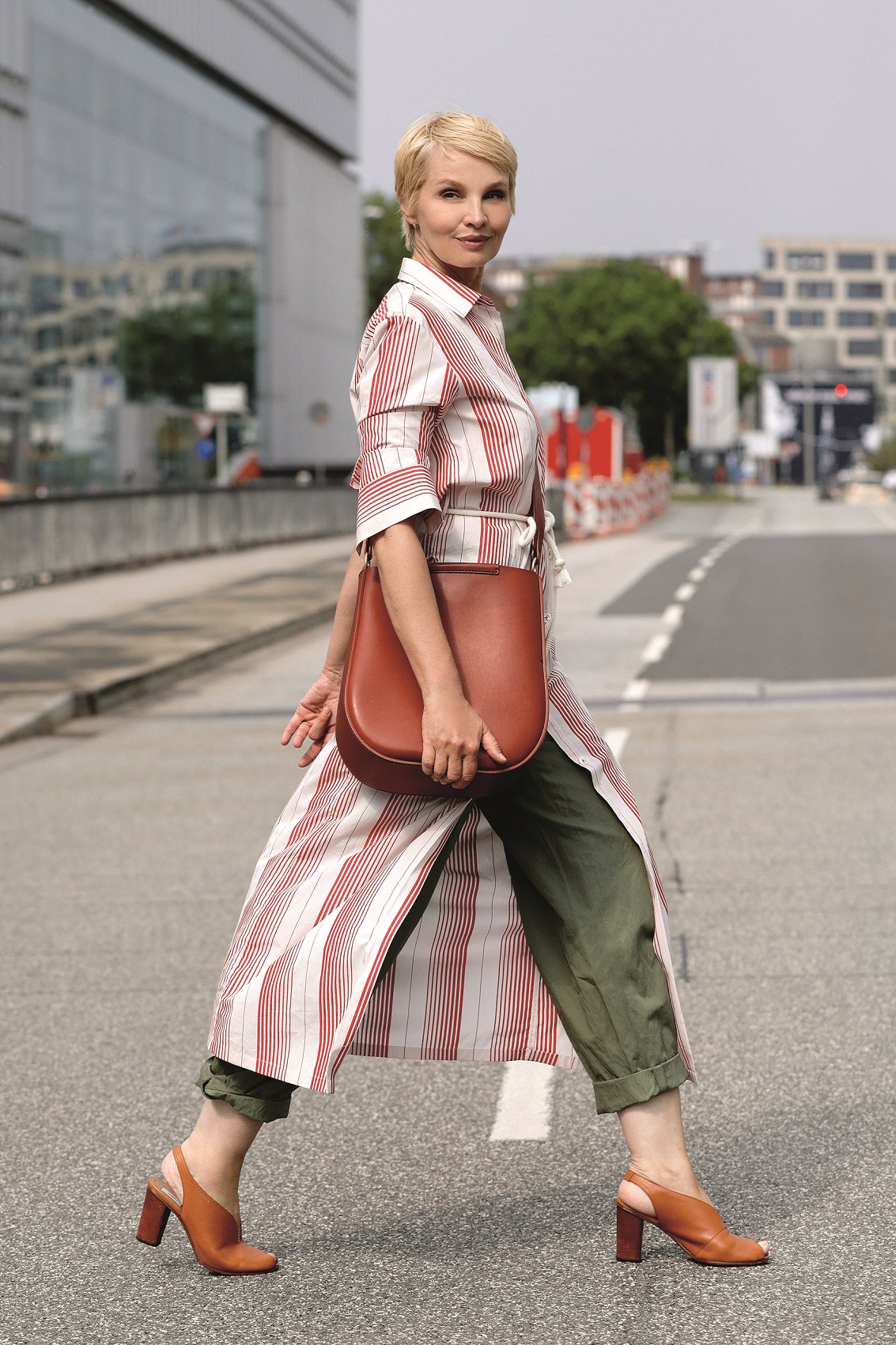 HAMBURG, GERMANY - JULY 06: German presenter Susann Atwell wearing a brown bag by Stiebich & Rieth, brown sandals by Closed, olive green pants and a long red and white blouse by Odeeh during a street style shooting on July 6, 2020 in Hamburg, Germany. (Photo by Streetstyleshooters/Getty Images)