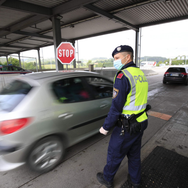 An Austrian policemen looks at cars crossing the Austrian-Slovenian border at the checkpoint near Spielfeld, Austria, on June 5, 2020