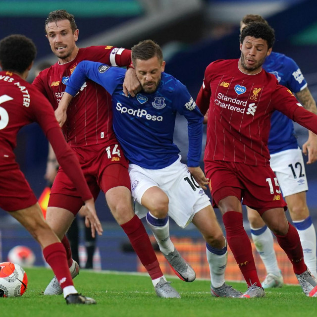 TOPSHOT - Everton's Icelandic midfielder Gylfi Sigurdsson (C) vies for the ball against Liverpool's English midfielder Alex Oxlade-Chamberlain (R) and Liverpool's English midfielder Jordan Henderson (2nd L) during the English Premier League football match between Everton and Liverpool at Goodison Park in Liverpool, north west England on June 21, 2020. (Photo by Jon Super/POOL/AFP)/RESTRICTED TO EDITORIAL USE. No use with unauthorized audio, video, data, fixture lists, club/league logos or 'live' services. Online in-match use limited to 120 images. An additional 40 images may be used in extra time. No video emulation. Social media in-match use limited to 120 images. An additional 40 images may be used in extra time. No use in betting publications, games or single club/league/player publications./