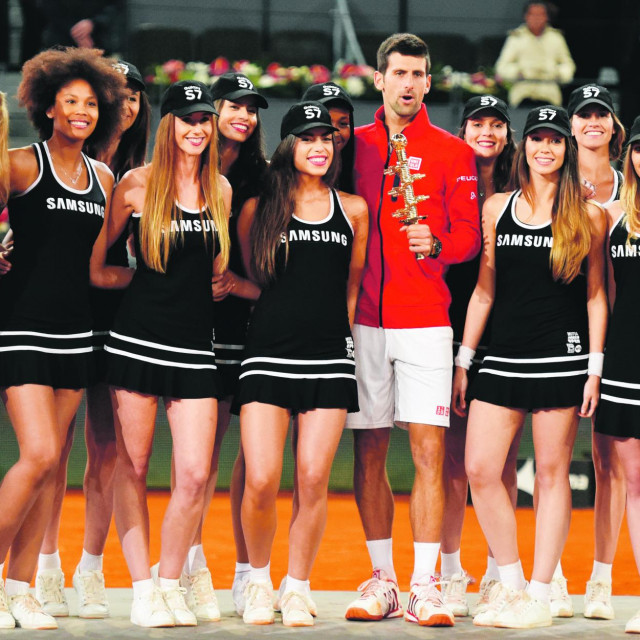 Serbia's Novak Djokovic poses with ball girls after beating Britain's Andy Murray during the Madrid Open men's tennis final at the Caja Magica (Magic Box) sports complex in Madrid on May 8, 2016. (Photo by GERARD JULIEN/AFP)