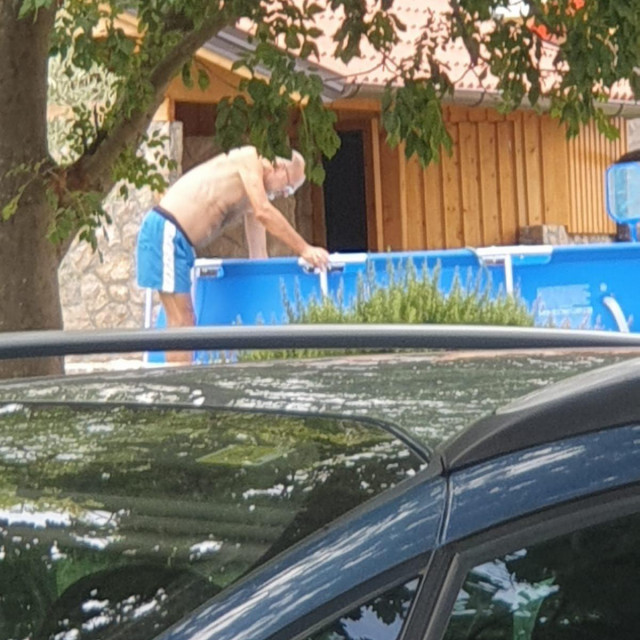 Jelko Kacin čisti svoj bazen ispred kuće na Krku