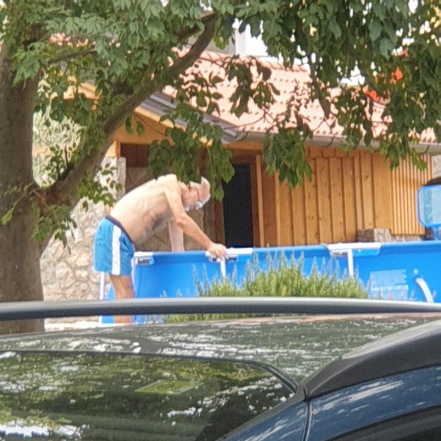 Jelko Kacin čisti svoj bazen ispred kuće