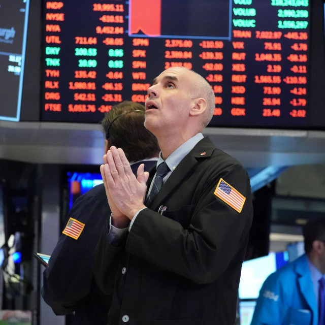 (FILES) In this file photograph taken on March 18, 2020, traders work on the floor at the opening bell of the Dow Industrial Average at the New York Stock Exchange in New York. - The coronavirus has upended everyday life in the six months since the crisis was declared a pandemic by the World Health Organization (WHO). While our understanding of the new respiratory disease has steadily increased since it was first detected in China last year, what lies ahead over the next half-year remains unknown. (Photo by Bryan R. Smith/AFP)