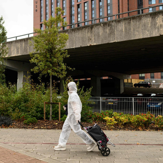 Student u punoj zaštitnoj opremi ide prema knjižnici Sveučilišta Coventry