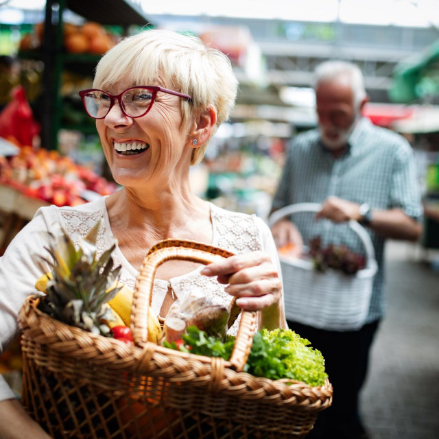 Senior couple buying fresh vegetables at the local market
