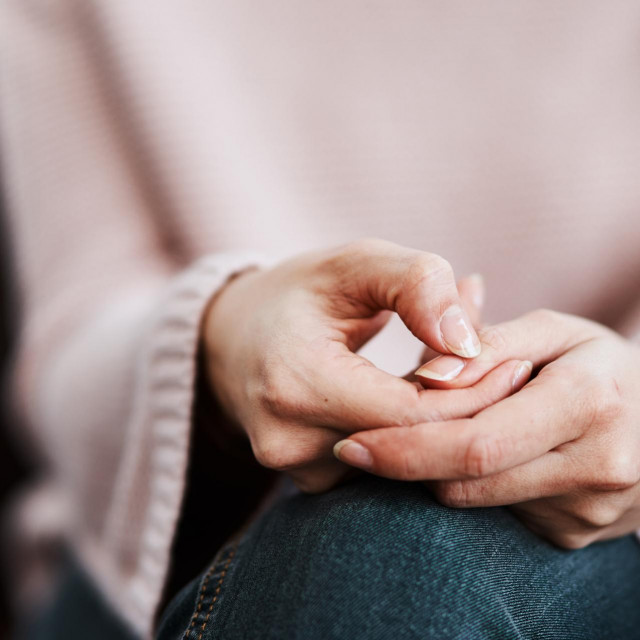 Cropped shot of a woman sitting on a sofa and feeling anxious