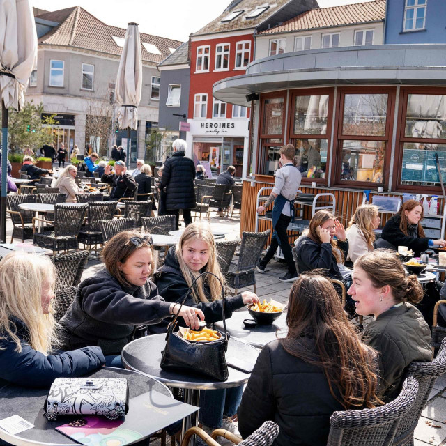 People enjoy outdoor service in Roskilde, Denmark, on April 21, 2021, as cafes and bars reopen amid the coronavirus (Covid-19) pandemic. - As of April 21, bars, cafes and restaurants reopen in Denmark. Serving stops at 10pm, the establishment must be closed from 11pm until 5am. (Photo by Claus Bech/Ritzau Scanpix/AFP)/Denmark OUT