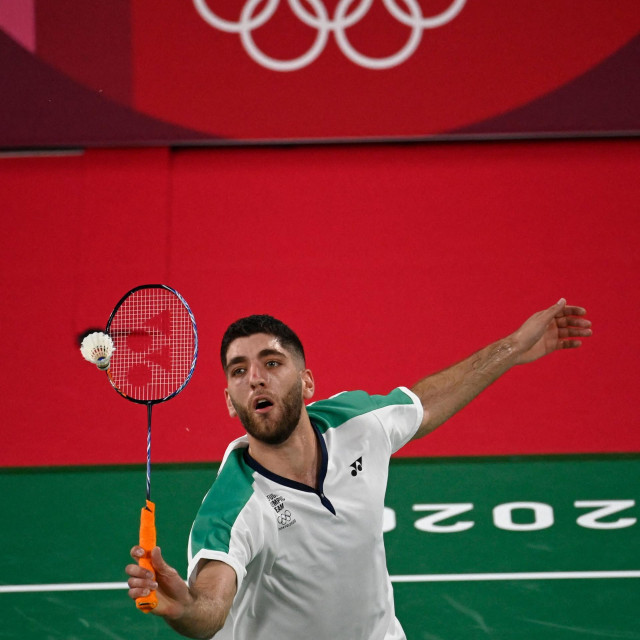 Refugee Olympic Team's Aram Mahmoud hits a shot to Singapore's Loh Kean Yew in their men's singles badminton group stage match during the Tokyo 2020 Olympic Games at the Musashino Forest Sports Plaza in Tokyo on July 26, 2021. (Photo by Alexander NEMENOV/AFP)