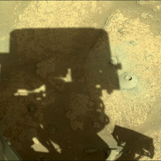 Sjena rovera pokraj prve iskopane rupe na Marsu