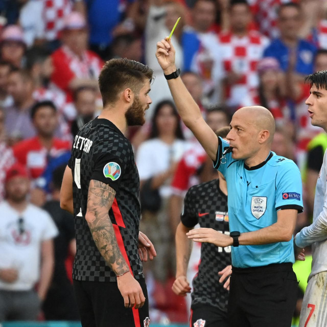 Turkish referee Cuneyt Cakir presents a yellow card to Croatia&amp;#39;s defender Duje Caleta-Car (L) during the UEFA EURO 2020 round of 16 football match between Croatia and Spain at the Parken Stadium in Copenhagen on June 28, 2021. (Photo by Jonathan NACKSTRAND/POOL/AFP)