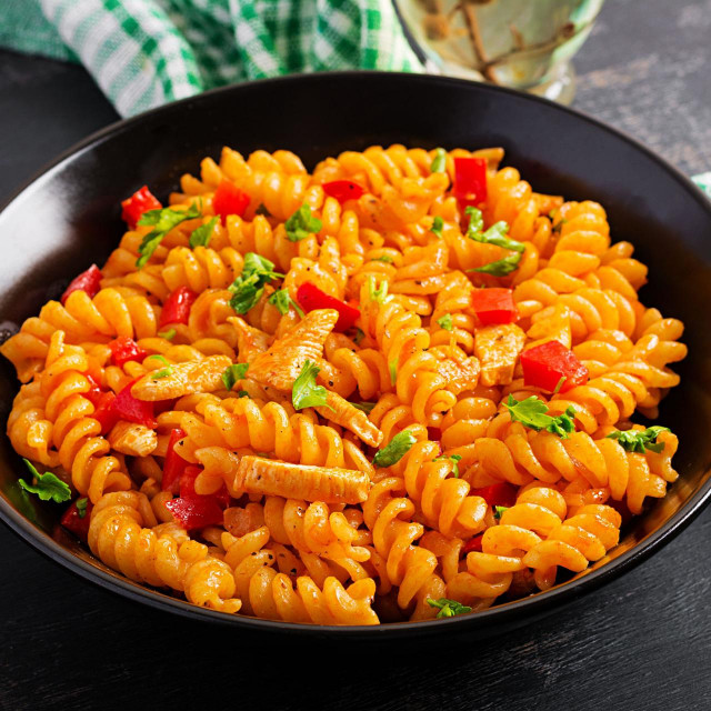 2BMEGHX Fusilli pasta with chicken and sweet pepper in tomato sauce. Italian Cuisine.
