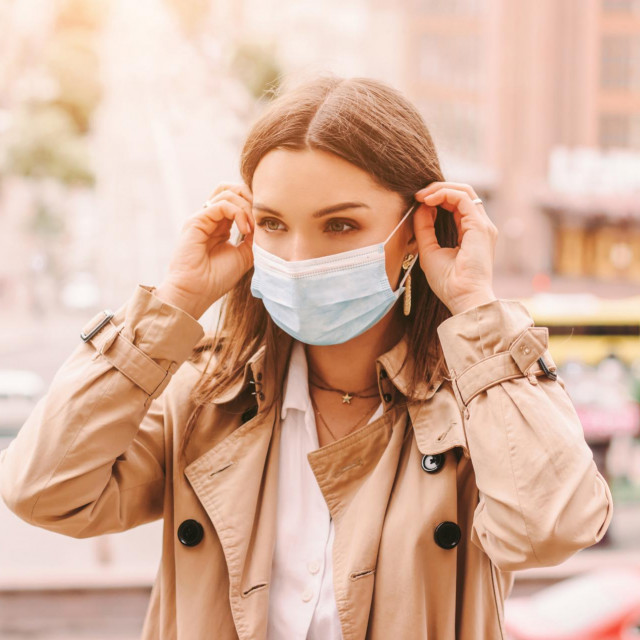 &lt;p&gt;Beautiful stylish girl wear medical face mask on sunny city street. Young elegant happy hipster woman put on protective face mask outdoors. Urban fashion outfit, lifestyle. COVID-19 quarantine, travel&lt;/p&gt;
