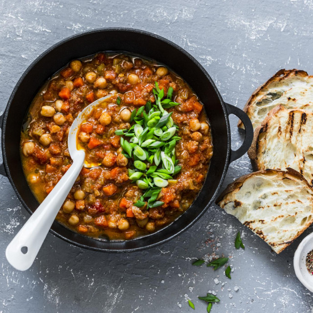 &lt;p&gt;Vegetarian mushrooms chickpea stew in a iron pan and rustic grilled bread on a gray background, top view. Healthy vegetarian food concept. Vegetarian chili&lt;/p&gt;
