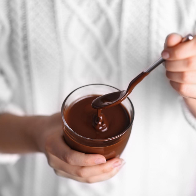 <p>Woman holding glass cup with chocolate mousse, closeup</p>