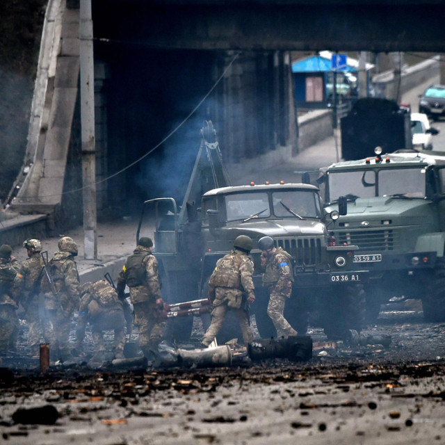 Ukrajinski vojnici pokraj uništenog konvoja vojnih vozila na zapadu Kijeva
