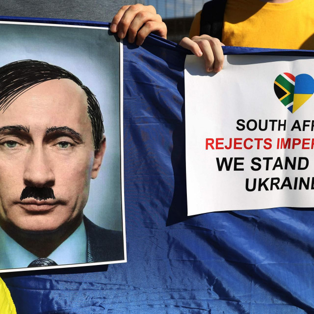 Prosvjed podrške Ukrajini; prosvjednik drži portrert Putina pretvorenog u Hitlera
