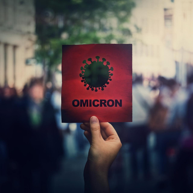 &lt;p&gt;Omicron the new variant of the Covid-19 virus, coronavirus mutations, sars-cov-2 strain. Hand holds red banner warning in the crowded streets. Another wave of pandemic outbreak&lt;/p&gt;